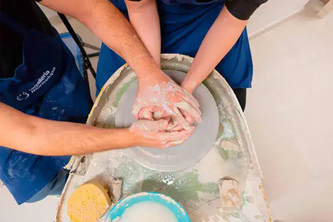 Hands shaping clay during a pottery class at La Galleria, Florence.